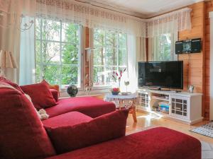 a living room with a red couch and a tv at Holiday Home Sipukka by Interhome in Meltaus