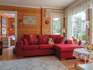 a red couch in a living room with wooden walls at Holiday Home Sipukka by Interhome in Meltaus