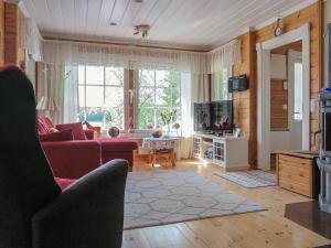 a living room with a red couch and a tv at Holiday Home Sipukka by Interhome in Meltaus