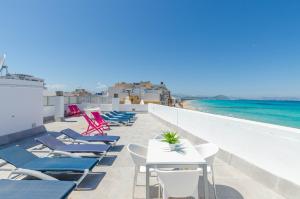 a row of chairs and tables on a balcony with the ocean at Yourhouse Blau Blue 2 3 in Can Picafort