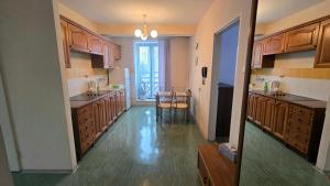 a large kitchen with wooden cabinets and a table at Osiedle Studenckie w Słubicach in Słubice