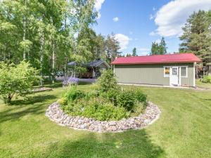 a garden with a rock circle in front of a building at Holiday Home Isoniemi by Interhome in Suinula