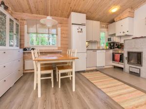 a kitchen with a wooden table and chairs at Holiday Home Isoniemi by Interhome in Suinula +11 photos