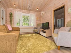 a living room with two couches and a television at Holiday Home Isoniemi by Interhome in Suinula