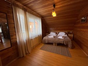 a bedroom with a bed in a wooden cabin at WOOD house in Skhidnitsa