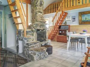 a stone fireplace in a living room with a staircase at Holiday Home Kerkkälä by Interhome in Luosto