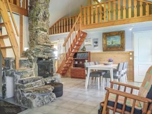 a living room with a stone fireplace and a table at Holiday Home Kerkkälä by Interhome in Luosto