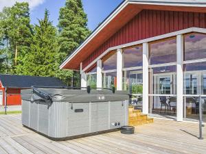 a hot tub on a deck in front of a house at Holiday Home Villa blomvik by Interhome in Kristenäs