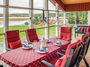 a dining room with a table with red chairs and a tableablish at Holiday Home Villa blomvik by Interhome in Kristenäs