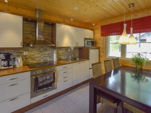a kitchen with white cabinets and a table with chairs at Holiday Home Sointukallio by Interhome in Savonlinna +29 photos