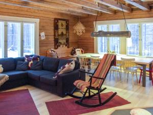 a living room with a blue couch and a table at Holiday Home Seppola by Interhome in Ruka