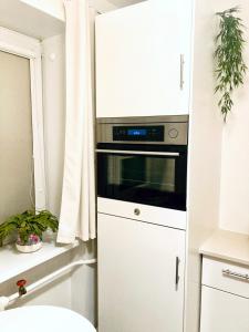 a kitchen with a stove and a white cabinet at Apartment City Heart in Valmiera