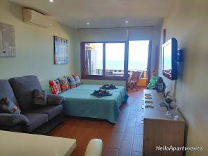 a living room with a bed and a couch at Sea View Playa Arena by HelloApartments in Puerto de Santiago