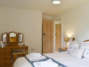 a bedroom with a bed with white sheets and a mirror at Cherry Cottage - Ukc3990 in South Perrott +8 photos