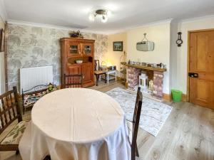 a dining room with a table and a fireplace at The Painters Cottage in Heckington