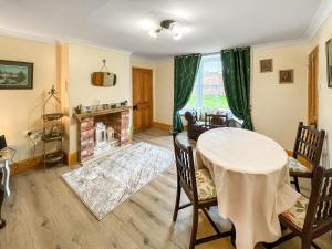 a dining room with a table and a fireplace at The Painters Cottage in Heckington