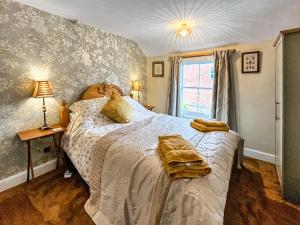 a bedroom with a bed with two towels on it at The Painters Cottage in Heckington +11 photos