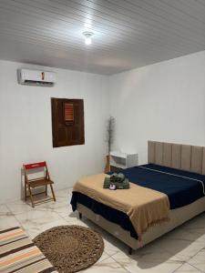a bedroom with a bed and a chair in a room at Cajuí da Vila Atins in Atins