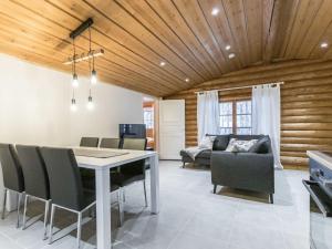 a dining room with a table and chairs and a couch at Holiday Home Honkakeko by Interhome in Levi
