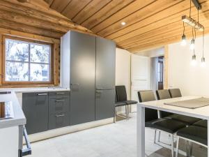 a kitchen with gray cabinets and a table and chairs at Holiday Home Honkakeko by Interhome in Levi +24 photos
