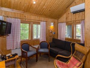 a living room with a couch and two chairs at Holiday Home Ulpukka by Interhome in Savilahti
