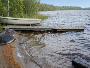 a boat sitting on a dock on a lake at Holiday Home Ulpukka by Interhome in Savilahti