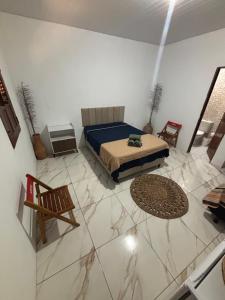 a bedroom with a bed and a tiled floor at Cajuí da Vila Atins in Atins