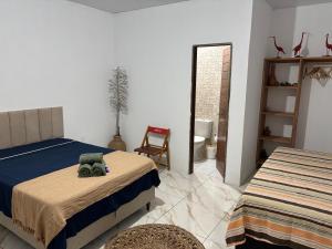 a bedroom with two beds and a stuffed animal on the bed at Cajuí da Vila Atins in Atins