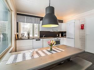 a kitchen with a table with a vase of flowers on it at Holiday Home Pallaskieppi by Interhome in Kyrö