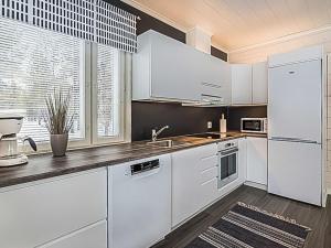 a white kitchen with white cabinets and a window at Holiday Home Pallaskieppi by Interhome in Kyrö
