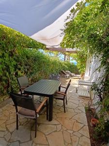 a picnic table and chairs on a stone patio at Chez Béa in Lumio