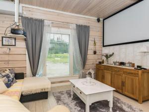 a living room with a couch and a large screen at Holiday Home Suviranta by Interhome in Suonenjoki