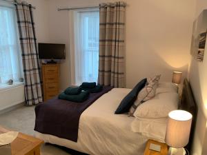 a bedroom with a large bed and a television at 2 Windsor House in Keswick
