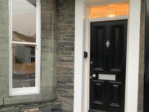 a black door to a house with a window at 2 Windsor House in Keswick +7 photos