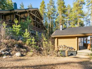a log cabin with a porch and a building at Holiday Home Roopenranta by Interhome in Asikkala