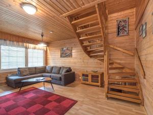 a living room with a couch and stairs in a cabin at Holiday Home Lomamaja 1 by Interhome in Raattama