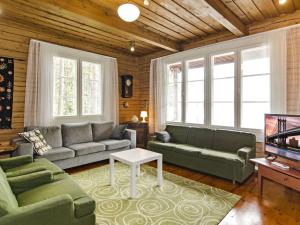 a living room with couches and a tv at Holiday Home Honkaniemi by Interhome in Rasivaara +19 photos