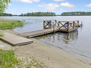 a wooden dock in the middle of a lake at Holiday Home Honkaniemi by Interhome in Rasivaara