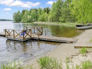 a dock on a body of water with a boat at Holiday Home Honkaniemi by Interhome in Rasivaara