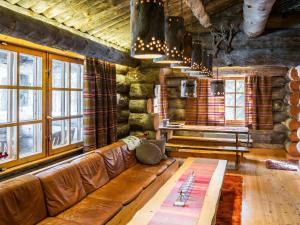 a living room with a leather couch and a table at Holiday Home Suutarinkolo by Interhome in Levi