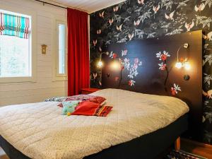a bedroom with a bed with a flower wall at Holiday Home Teppolan rinne by Interhome in Salla