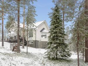 a house in the snow with a tree at Holiday Home Teppolan rinne by Interhome in Salla +22 photos