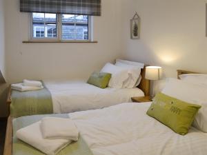 a room with three beds and a window at Clover Cottage in Keswick