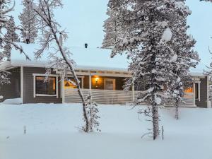 a house in the snow with snow covered trees at Holiday Home Hilla b by Interhome in Saariselka