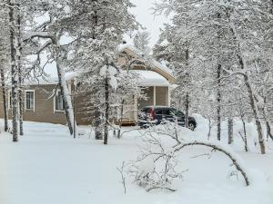 a house covered in snow with a car parked in front at Holiday Home Hilla b by Interhome in Saariselka +14 photos