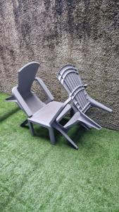 two chairs sitting on the grass next to a wall at Titanic History Private Home in Belfast
