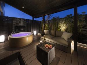 a patio with a tub and a couch and a table at HOTEL SWEET SEASON-L in Ginan
