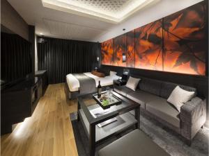 a living room with a couch and a bed at HOTEL SWEET SEASON-L in Ginan