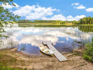 a boat parked next to a dock on a lake at Holiday Home Kaisla by Interhome in Pertunmaa