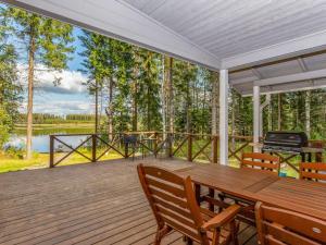 a screened porch with a wooden table and chairs at Holiday Home Kaisla by Interhome in Pertunmaa